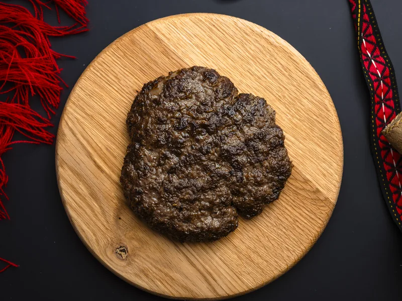Lamb pljeskavica on a plate, made of beef and lamb, at Trafika