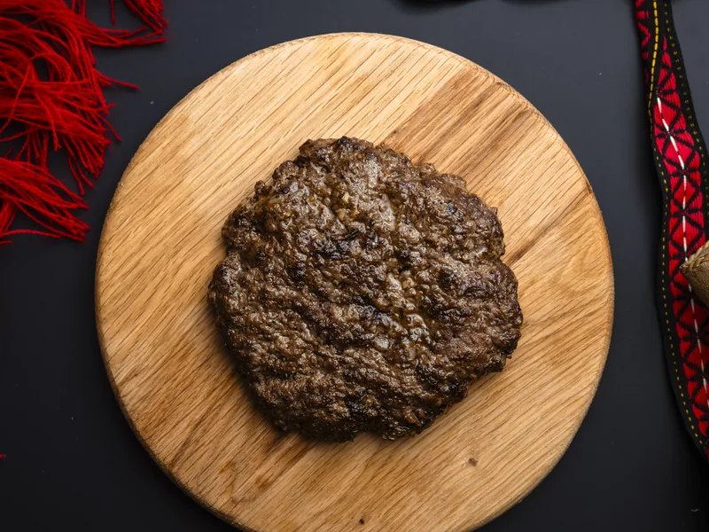 Classic pljeskavica on a plate, made of beef, at Trafika