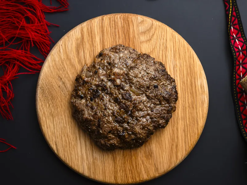 Trafika pljeskavica on a plate with parmesan and pancetta